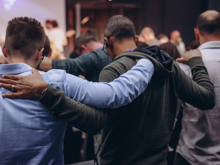 Members of a community group standing together, arms around each other