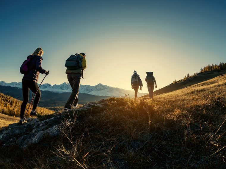 A walking group heading up a hillside at sunset