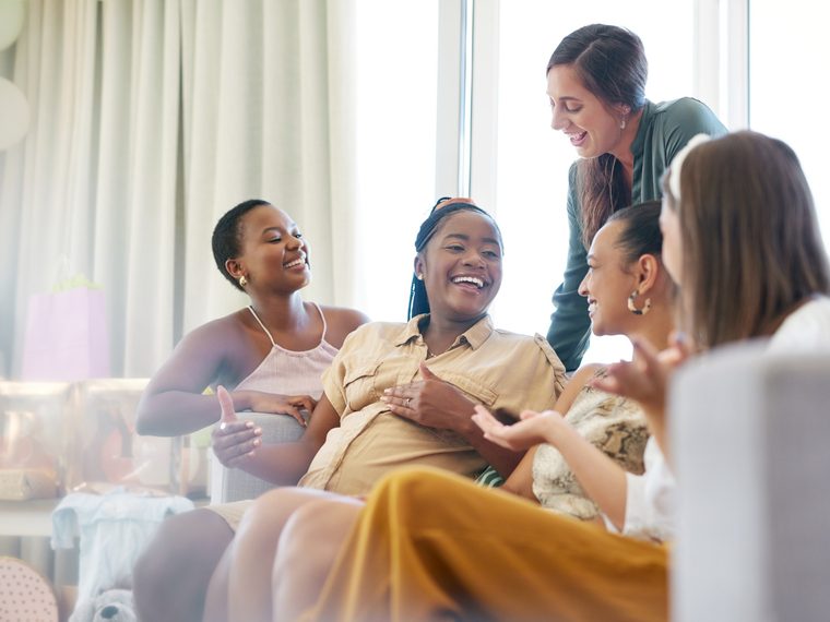 Friends laughing together at a baby shower