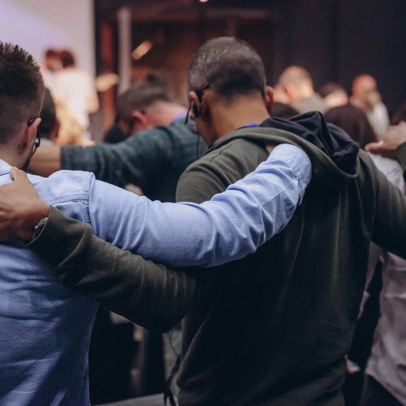 Members of a community group standing together, arms around each other